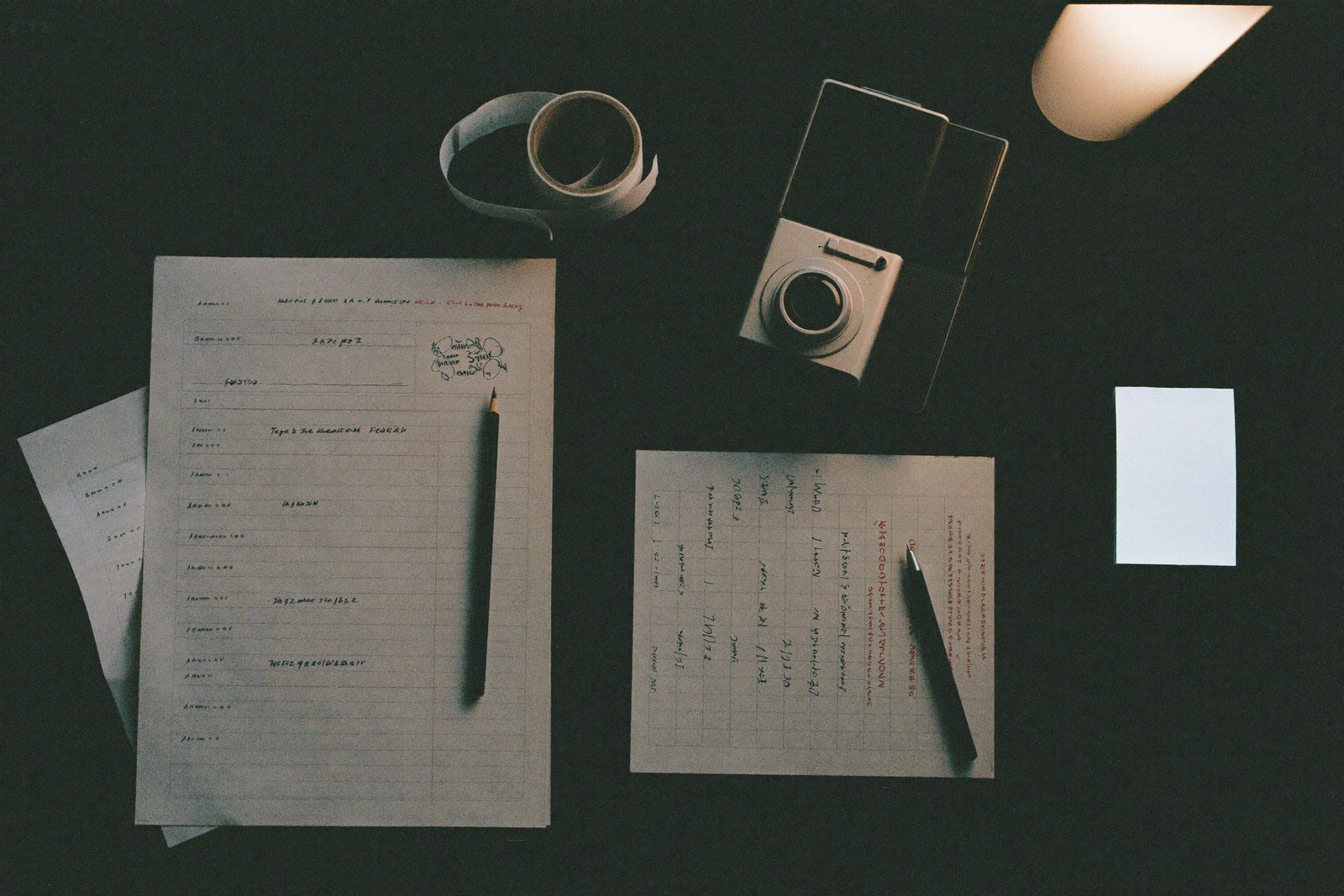 A desk from above: checklists, a call sheet, gaffer tape, a pencil